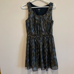 Iz Beyer sleeveless black dress w/ gold/silver mini-square stripes.  Knee Length